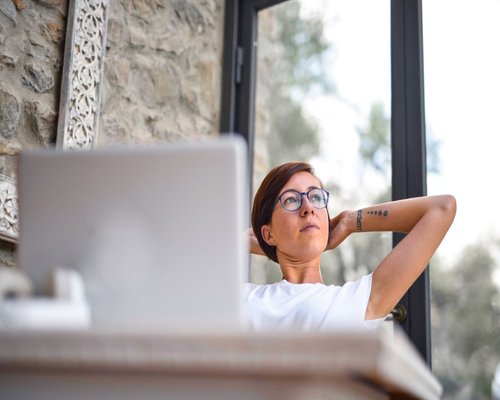 person taking a short break looking away from the laptop screen